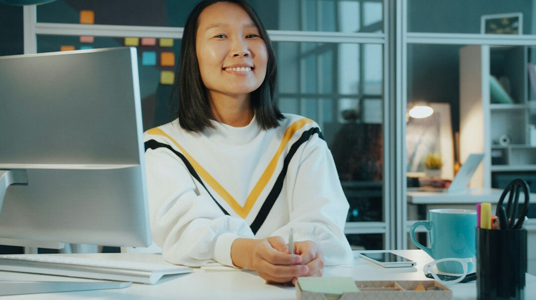 Young Croatian woman smiling while working on a laptop